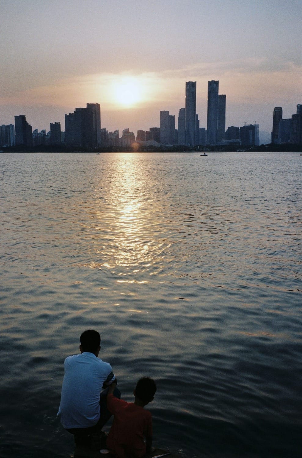 Vater und Kind am See im Sonnenuntergang